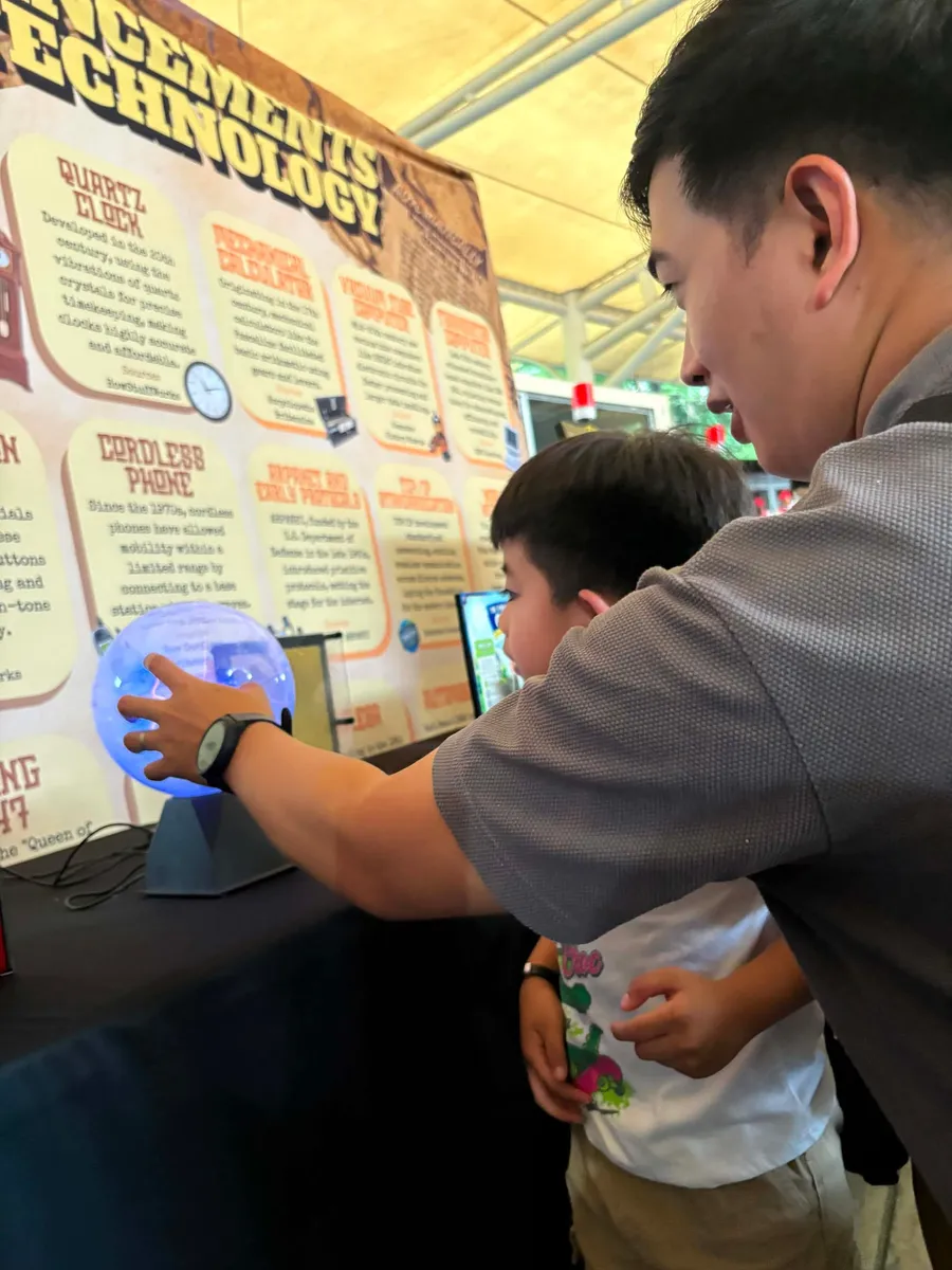 A visitor touching the plasma lamp exhibit