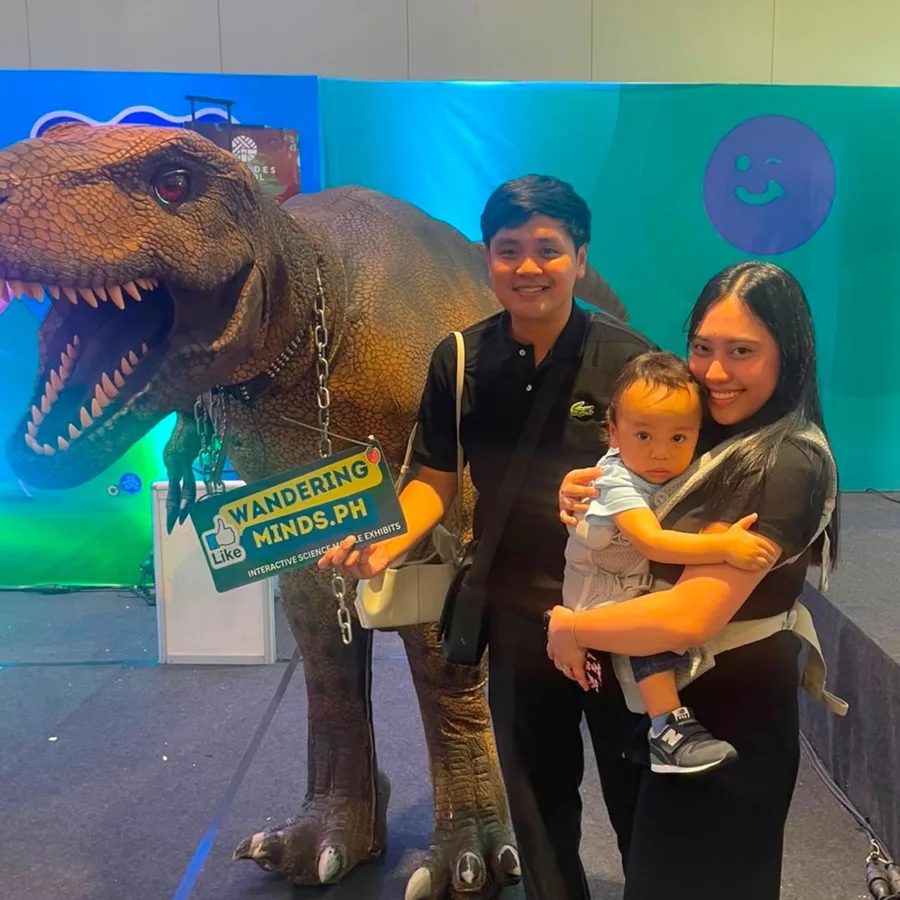 Parents and their baby posing with the Wandering Minds Jurassic T-Rex at the EDAMAMA New Mama Expo 2026