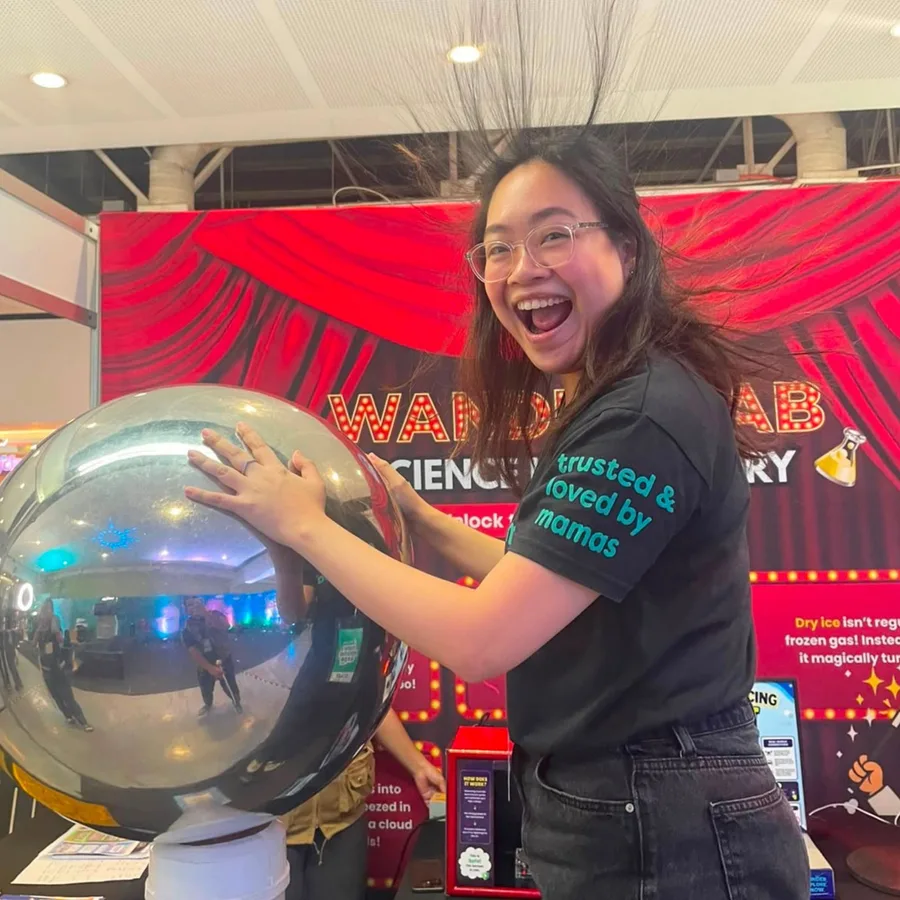 A Wandering Minds host demonstrating static electricity at the WanderLab Science Discovery booth